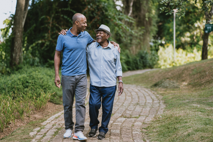 Elderly father and adult son walking