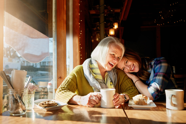 Young woman and her senior mother bonding together in a cafe