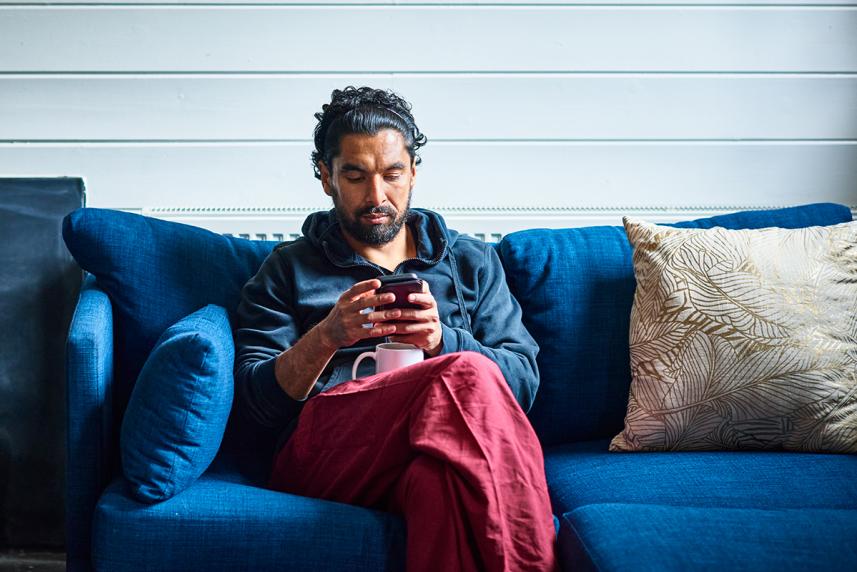 Man sitting on the couch looking at his phone